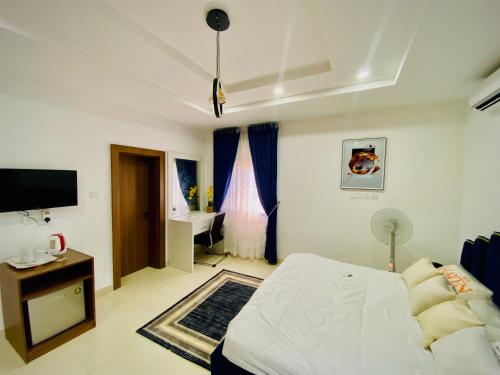 阿布贾Abuja Getaways的一间卧室配有一张床、一张书桌和一台电视
