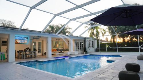 迈阿密Home in Miami的一个带遮阳伞和房子的游泳池
