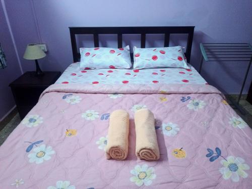 VelcaoBenirosa Homestay Apartments 2的粉红色的床和两张滚毛巾