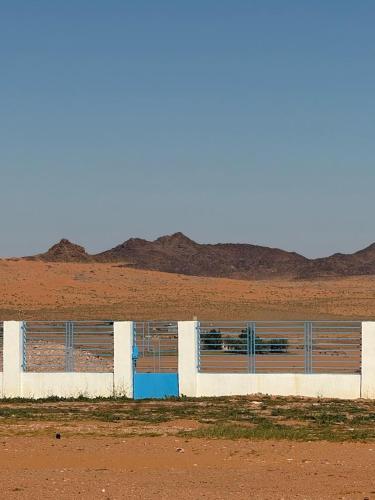 Al Qā‘idمزرعة ود的沙漠中间有蓝色门的建筑