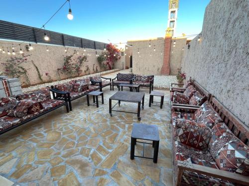 利雅德شاليهات حائط طيني的一个带沙发和桌子的庭院和一面墙