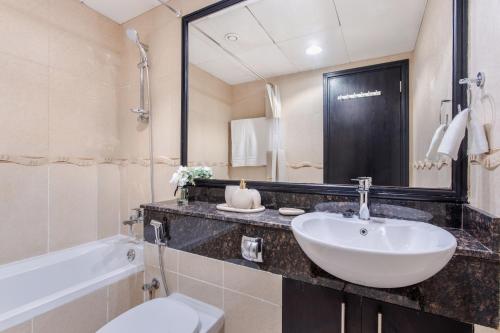 迪拜3 Bedroom Luxurious Lake View Apartment的浴室配有盥洗盆、卫生间和浴缸。