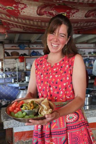 图利凯尔Hasera Organic Farmstay: Farm to Table & Mountain View的女人拿着一碗食物