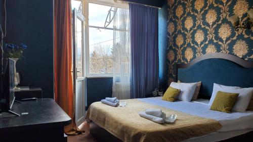 第比利斯Hotel Antalia的一间卧室配有带毛巾的床