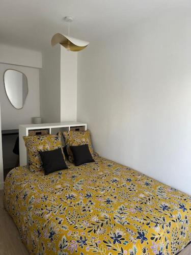 戛纳Joli F2, 7 min de la gare的一间卧室配有一张黄色和蓝色毯子的床