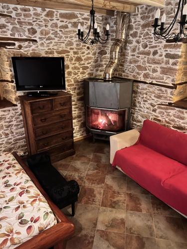 安吉斯乔治亚斯尼拉Magical cottage!的客厅设有壁炉和红色沙发。