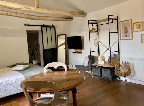丰特夫罗拉拜Studio la Grange的卧室配有一张床和一张桌子及椅子