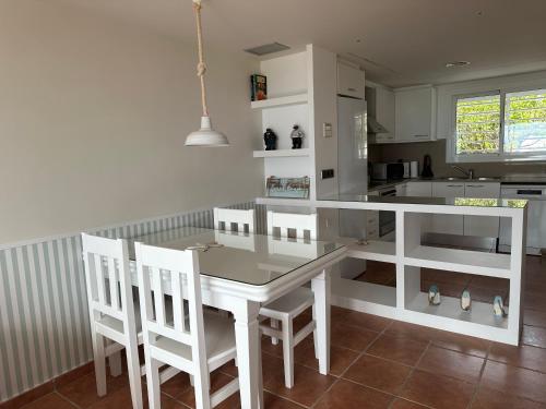 阿尔塔夫拉Villa Alex Altafulla Hermosa casa con espectaculares vistas al mar y a tocar de una idílica calita的厨房配有白色的桌椅