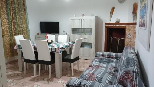 普罗斯西托角Casa Totò - Punta Prosciutto Apartment的一间带桌椅和电视的用餐室