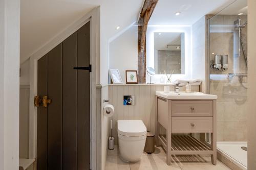惠特彻奇Oak Tree Hideaway的浴室配有卫生间、盥洗盆和浴缸。