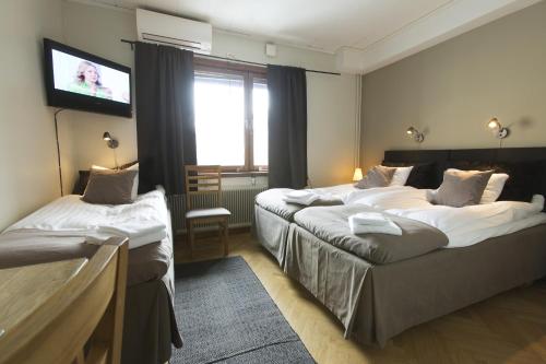 吕勒奥公园酒店的酒店客房设有两张床和一台平面电视。