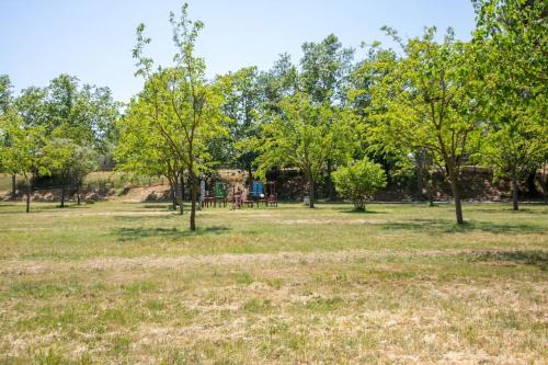 艾姆布里亚布拉瓦TRA9-CASA con BARBACOA, PISCINA comunitaria en verano, 5 min en coche del MAR y el CENTRO的一座树木繁茂的公园和一个位于后面的游乐场