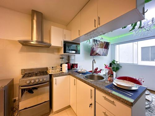 利马Apartamento Acogedor - BARRANCO的厨房配有水槽和炉灶
