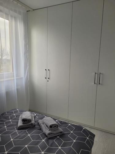 克拉科夫Apartament Mistral的客房设有带白色橱柜和毛巾的床。