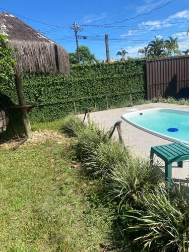 巴拉那州蓬塔尔Casa em Pontal do Paraná的庭院旁的游泳池,设有绿色长凳