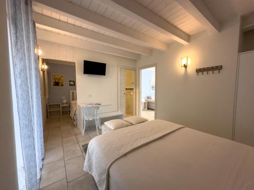 卡普里诺韦罗内塞Villa Nina - Apartments & Relax的一间卧室配有一张床、一张桌子和一台电视
