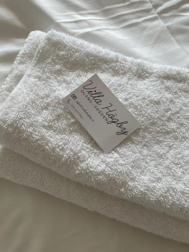 勒托普Villa Högby的床上有标志的白色毛巾