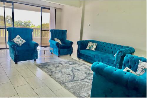 Ruirudeep east的客厅配有蓝色的沙发和地毯。