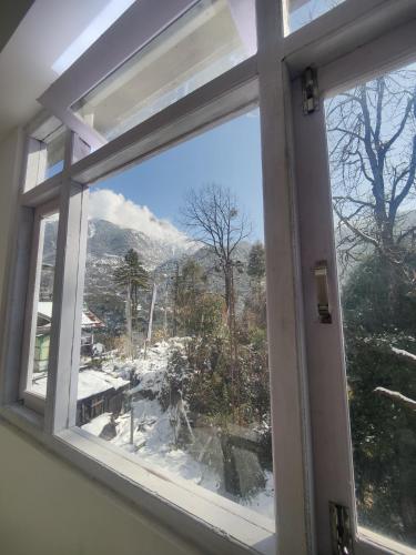 拉冲Samye hotel的开放式窗户,享有雪覆盖的山脉美景