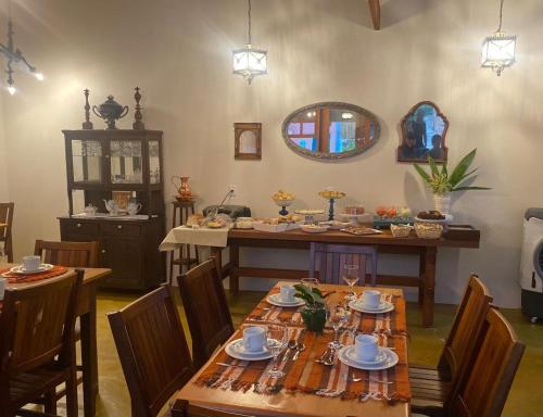 皮雷诺波利斯Pousada Mãe Natureza的一间带桌椅和镜子的用餐室