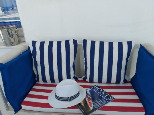 纳克索乔拉Yacht Marine Maison的条纹沙发上的帽子和书