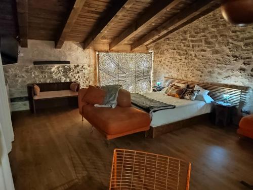 特连特Xana Casa Rural的一间卧室配有一张床、一张沙发和一把椅子