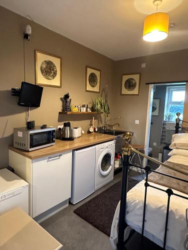 LincolnshireThe Stable Room at The Grange的客房设有带微波炉的厨房和1张床。