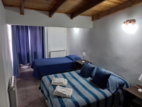 乌斯怀亚La Escondida的一间卧室配有两张蓝色床单
