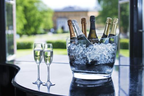 卡尔斯库加博福斯酒店的两杯葡萄酒坐在桌子上,备有香槟酒瓶