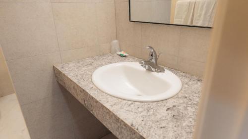 米西索加克拉克森村汽车旅馆 的浴室设有白色水槽和镜子