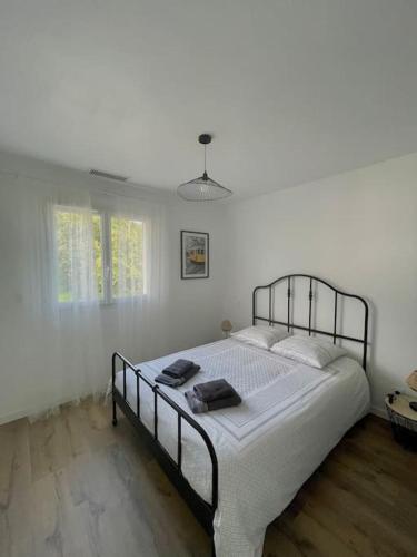 PomerolLe Logis de Pomerol的卧室配有一张带白色墙壁的大床