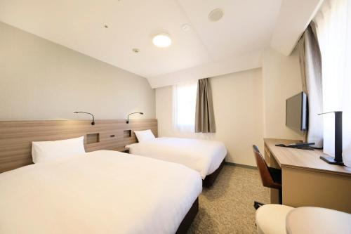 埼玉市Marroad inn omiya的酒店客房配有两张床和一张书桌