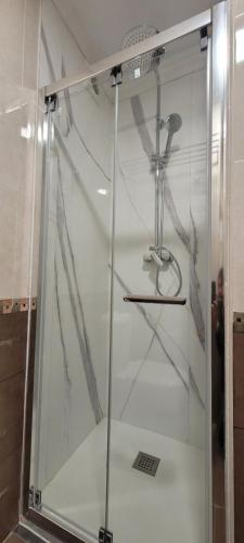 桑坦德Urbanizacion los Delfines的一间房间里带玻璃门的淋浴