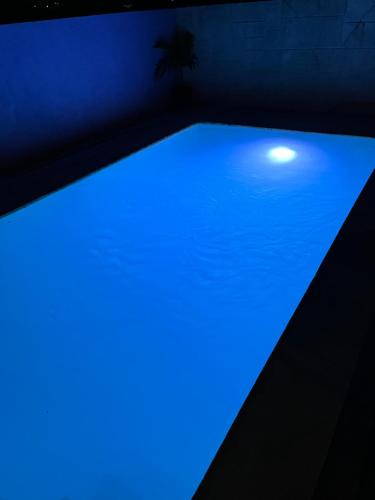 马尔斯港SanAndros Airbnb的深色客房内的蓝色灯光游泳池