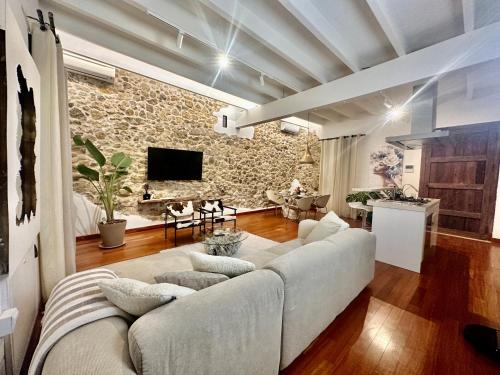 伊维萨镇Casa Klod Ibiza的客厅配有白色沙发和石墙