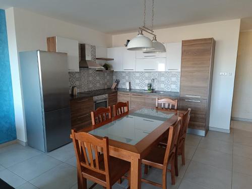 纳杜尔Gozo Spacious 3 Bathroom Apartment的厨房配有桌椅和冰箱。