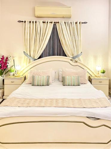 卡拉奇Mohalla Rooftop Retreat的卧室配有一张带两个枕头的大白色床
