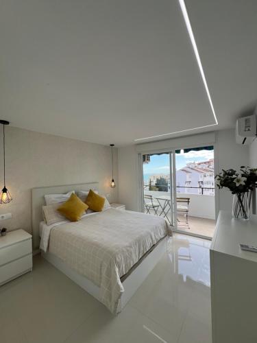 贝纳尔马德纳Luxury Bonanza的一间白色卧室,配有床和阳台