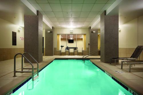 德梅因梅因市中心凯悦嘉轩酒店的大楼内一个带两把椅子的游泳池