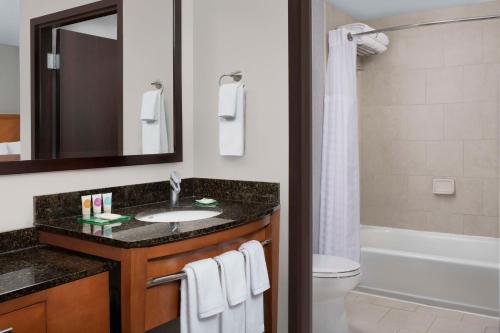 舒格兰糖城凯悦广场酒店的浴室配有盥洗盆、卫生间和浴缸。