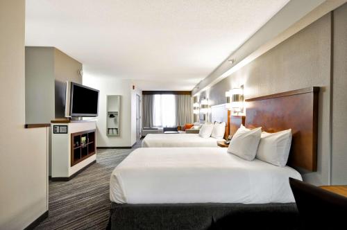 伊甸草原Hyatt Place Minneapolis Eden Prairie的酒店客房设有两张床和一台平面电视。