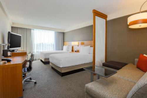 圣何塞凯悦广场圣何塞市中心酒店的大型酒店客房设有两张床和一张书桌