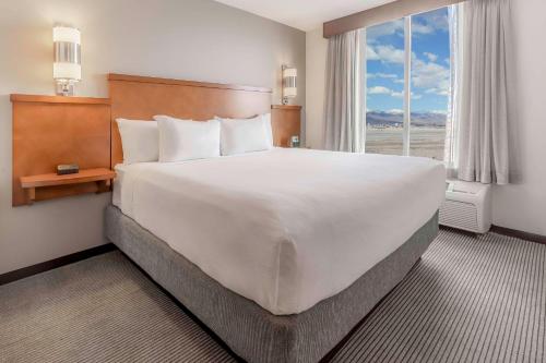 盐湖城盐湖城机场凯悦酒店的一张大白色床,位于酒店带窗户的房间内