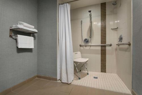 巴亚蒙巴亚蒙广场凯悦酒店的带淋浴的浴室和椅子