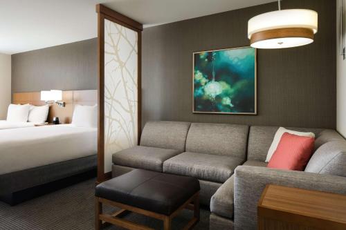 雷内克萨凯悦堪萨斯城莱内克萨城市中心公寓的酒店客房设有一张沙发和一张床