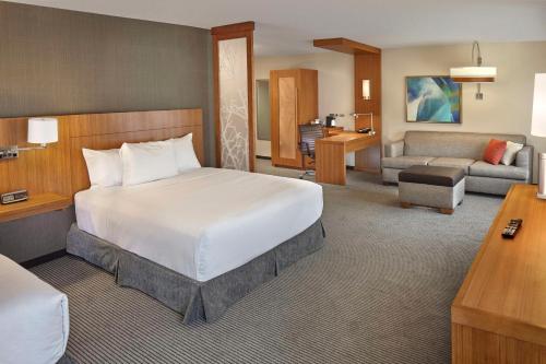 州学院州学院凯悦嘉轩酒店的一间带大床的卧室和一间客厅