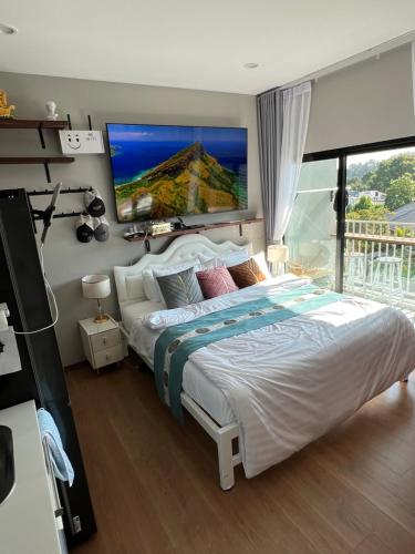 普吉镇Comfy 2-King Bed Condo - 3 Min to Rawai Beach at The Titile V Condo's的卧室配有一张大床,墙上配有电视