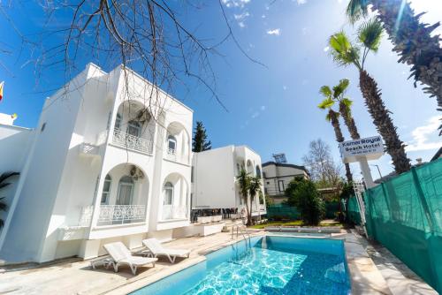 凯麦尔Kemer Royal Beach Hotel的白色的房子,设有游泳池和棕榈树