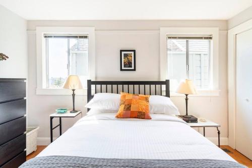 旧金山Secret Garden Stay - Perfect SF Location的一间卧室配有一张带两盏灯的大型白色床。