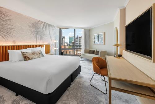 布里斯班Amora Hotel Brisbane的酒店客房设有一张大床和一台电视。